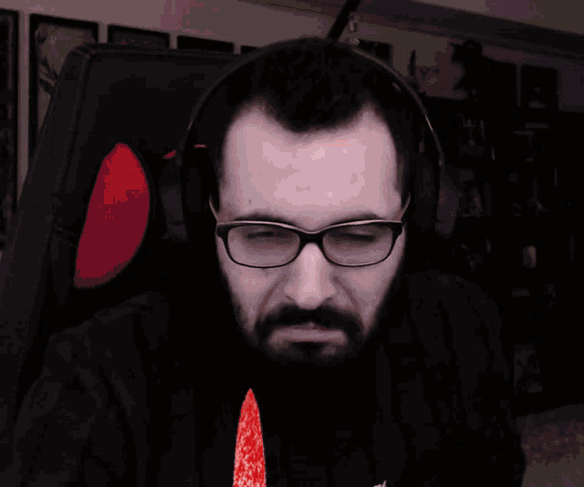 a man with glasses is holding a bloody knife in his hand