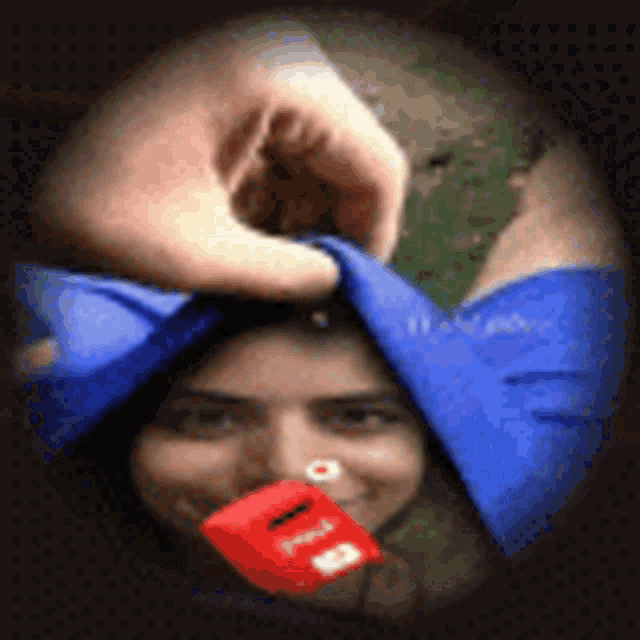 a woman is holding a red box in her mouth .