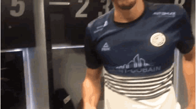 a man in a blue and white striped shirt with the word gobain on the front