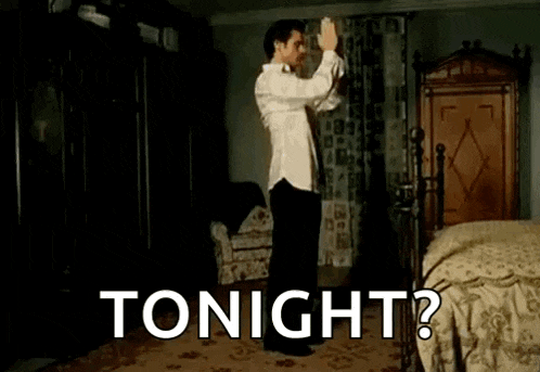 a man in a white shirt is dancing in a bedroom with the words `` tonight ? '' written on the bottom .