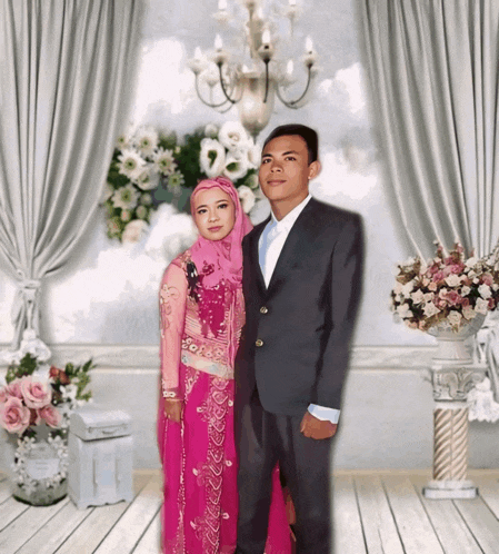 a man in a suit and a woman in a pink dress are posing for a photo