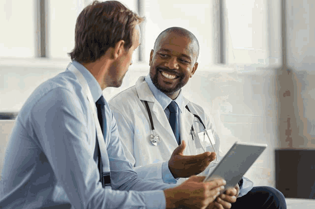 a doctor is smiling while talking to another man