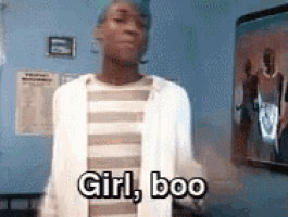 a man is standing in a room with the words girl boo written on his chest .