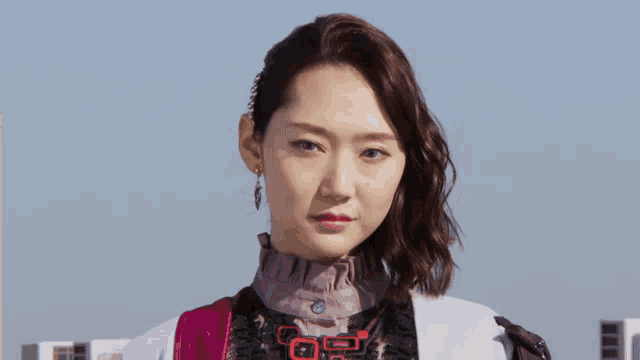 a woman wearing a white jacket and a purple vest has a chinese symbol on her chest