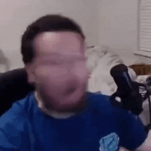 a man with a beard is talking into a microphone in a room .