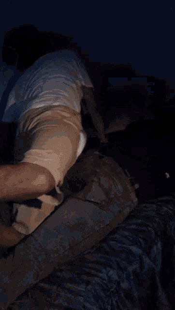 a blurred image of a person laying on a bed with a phone in the background