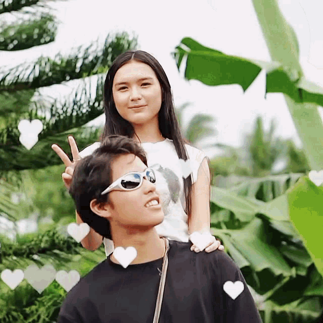 a girl wearing sunglasses sits on a man 's shoulders
