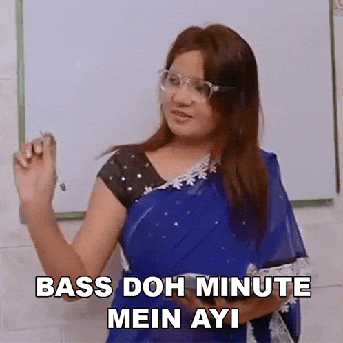 a woman in a blue saree is standing in front of a whiteboard with the words bass doh minute mein ayi written on it