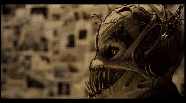 a close up of a monster 's face with barbed wire around it 's head