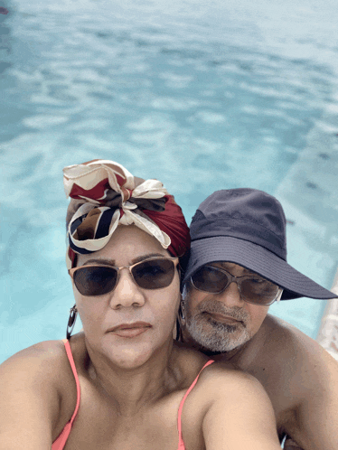 a man and a woman are posing for a photo in a pool