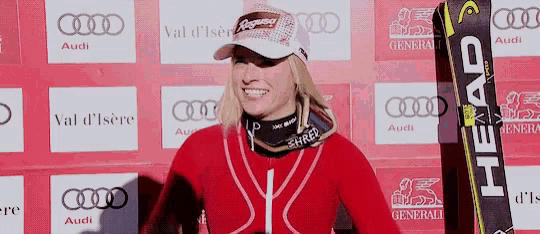 a woman holding a pair of skis that say head on them