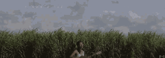 a woman playing a guitar in a field with the words " let your kingdom come " below her