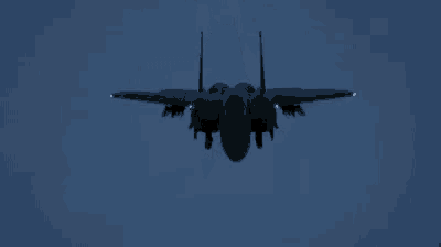 a fighter jet is flying in the night sky with smoke coming out of its tail .