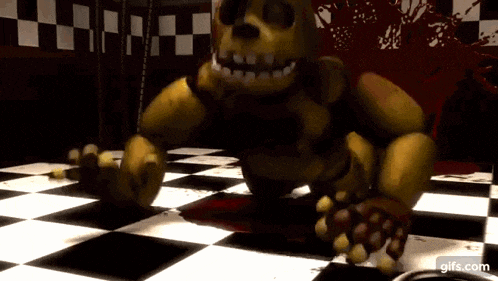 a yellow bear is sitting on a checkered floor in a dark room .