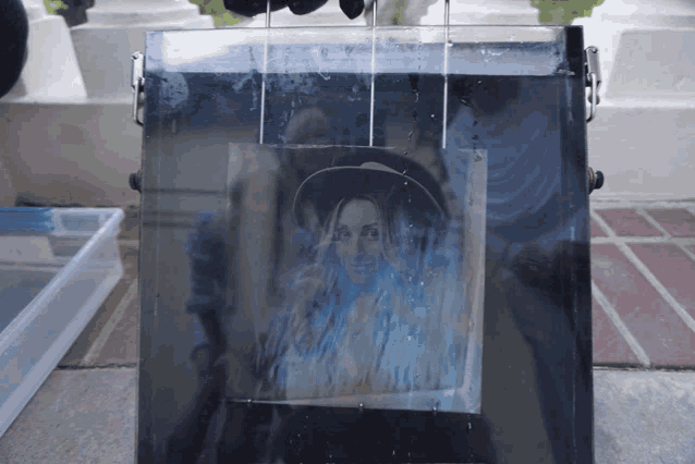a picture of a woman in a hat is being printed on a piece of plastic