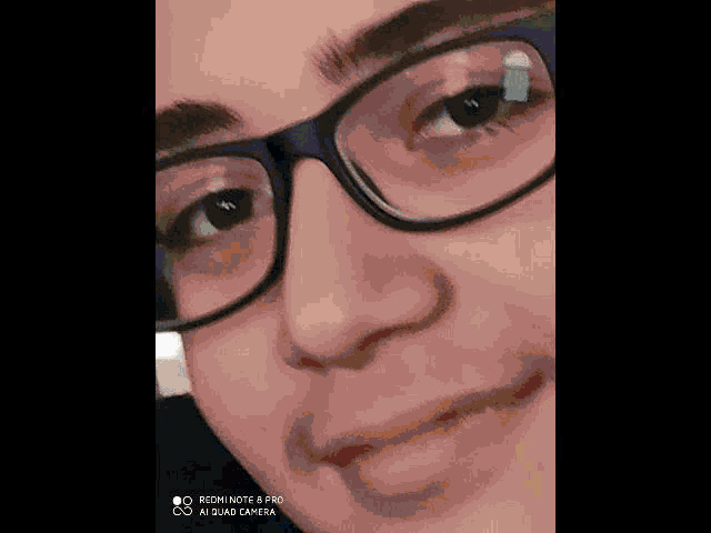 a close up of a person 's face with glasses on .