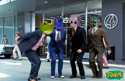 a group of men in suits are dancing in front of a building that says funkari