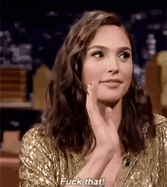 a woman is clapping her hands while wearing a gold dress .
