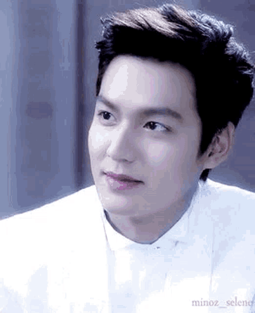 a close up of a man wearing a white shirt and tie .