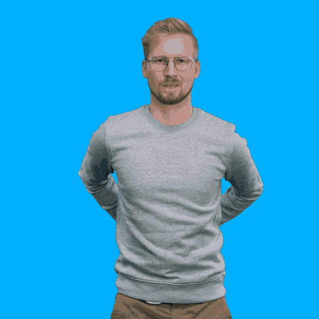 a man wearing a grey go spooks sweatshirt holds a camera