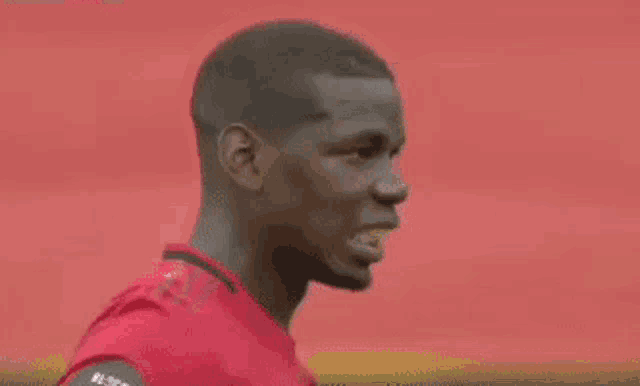 a man in a red shirt with the name pogba on the back