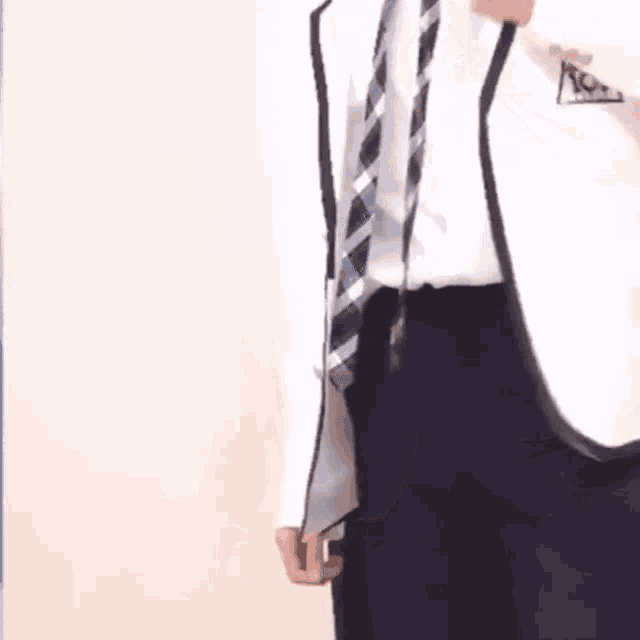 a man in a suit and tie is standing next to another man in a suit .