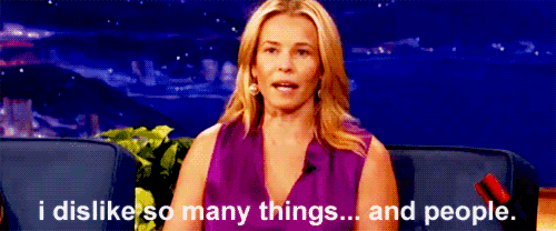 a woman in a purple shirt is sitting on a couch and says i dislike so many things and people