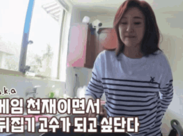 a woman in a striped shirt is cooking in a kitchen with foreign writing behind her