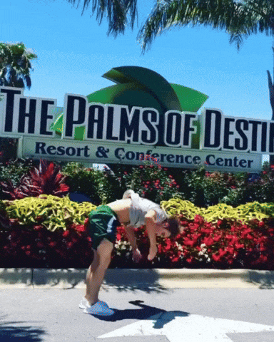 a man is doing a handstand in front of the palms of destiny resort and conference center
