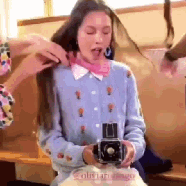 a woman is taking a picture of herself with a camera while wearing a bandana .