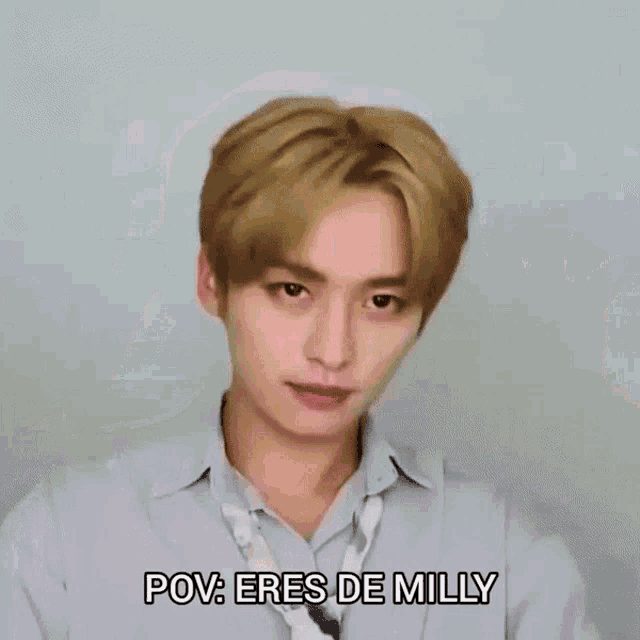 a young man with blonde hair is making a funny face and saying pov : eres de milly .