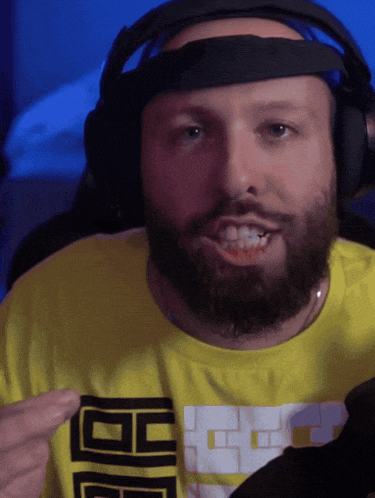 a man with a beard is wearing headphones and a yellow shirt that says bb on the front