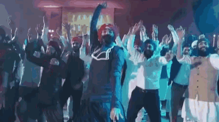a group of men are dancing together in a room with their hands in the air .