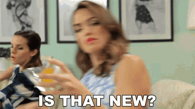 a woman is sitting on a couch holding a glass of orange juice and the words is that new above her