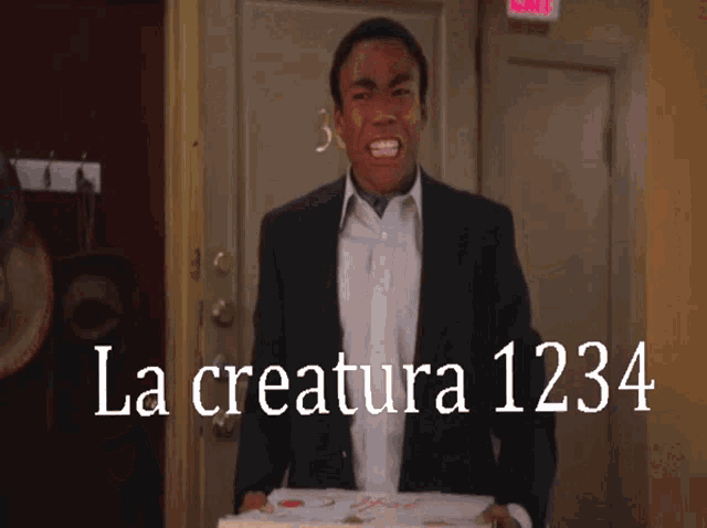 a man in a suit is holding a box of pizza and the words la creature 1234 are behind him