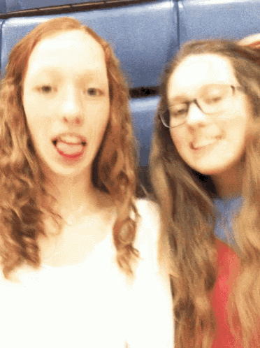 two girls are posing for a picture and one has her tongue hanging out