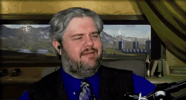 a man with a beard is wearing a blue shirt and a tie