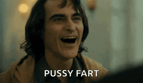 a close up of a man laughing with the words pussy fart written below him .