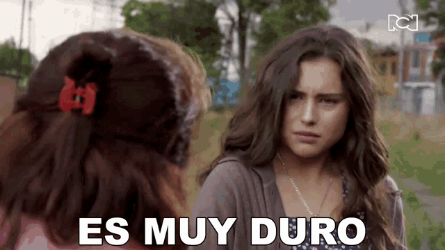 two girls are standing next to each other and the words es muy duro are on the screen