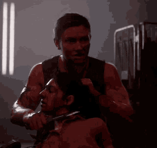 a man is cutting a woman 's neck with a knife in a dark room