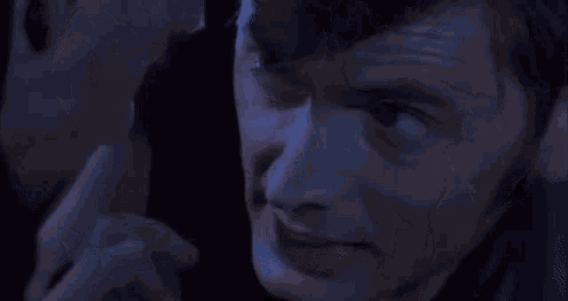 a man and a woman are looking at each other in a dark room .