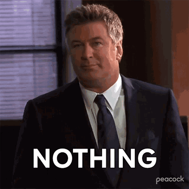 a man in a suit and tie is standing in front of a screen that says nothing
