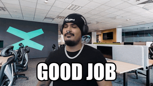 a man wearing headphones says " good job " in an office