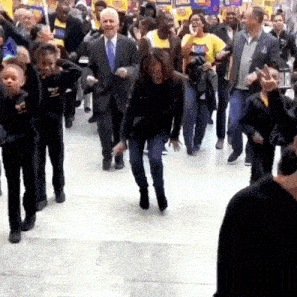 a group of people are dancing in a hallway with the words des moines iowa on the bottom right