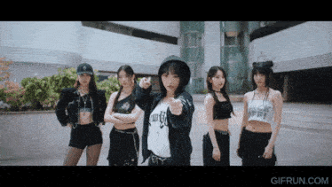 a group of young women are standing in front of a building with gifrun.com in the corner