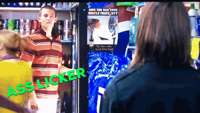 a man in a striped shirt is standing in front of a pepsi machine
