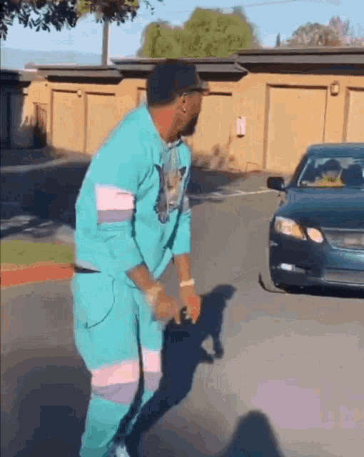 a man in a blue suit is dancing in front of a car .