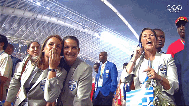 a group of women wearing olympic uniforms are laughing