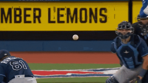 a baseball player with the number 61 on his jersey catching a ball