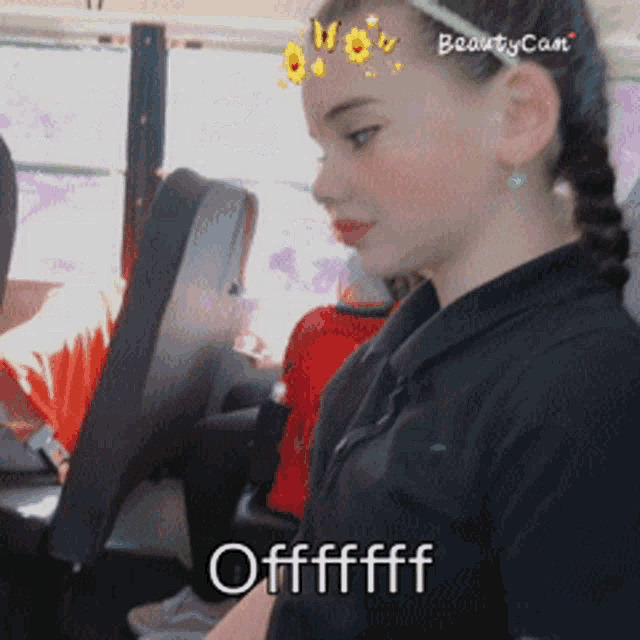 a girl in a black shirt is sitting in a car with the words offfffff written below her